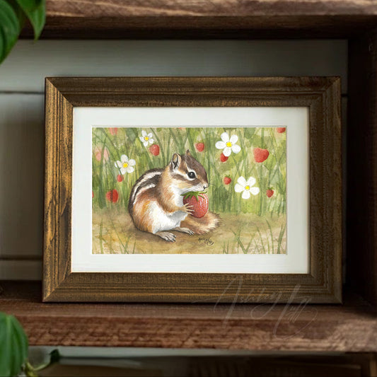 Framed limited edition art print of a chipmunk eating a fresh strawberry on a wooden shelf with plants.